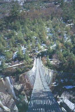 lange Hängebrücke und erster Schnee zwischen Bäumen