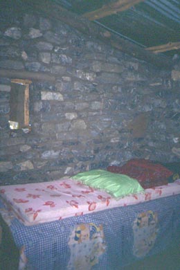 Bett zwischen dunklen Steinmauern