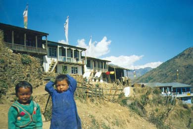 zwei Kinder vor ihrem Dorf